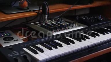 家庭音乐录音工作室工作区与混音板和键盘。声音工程师转动混音器上的旋钮。穆西